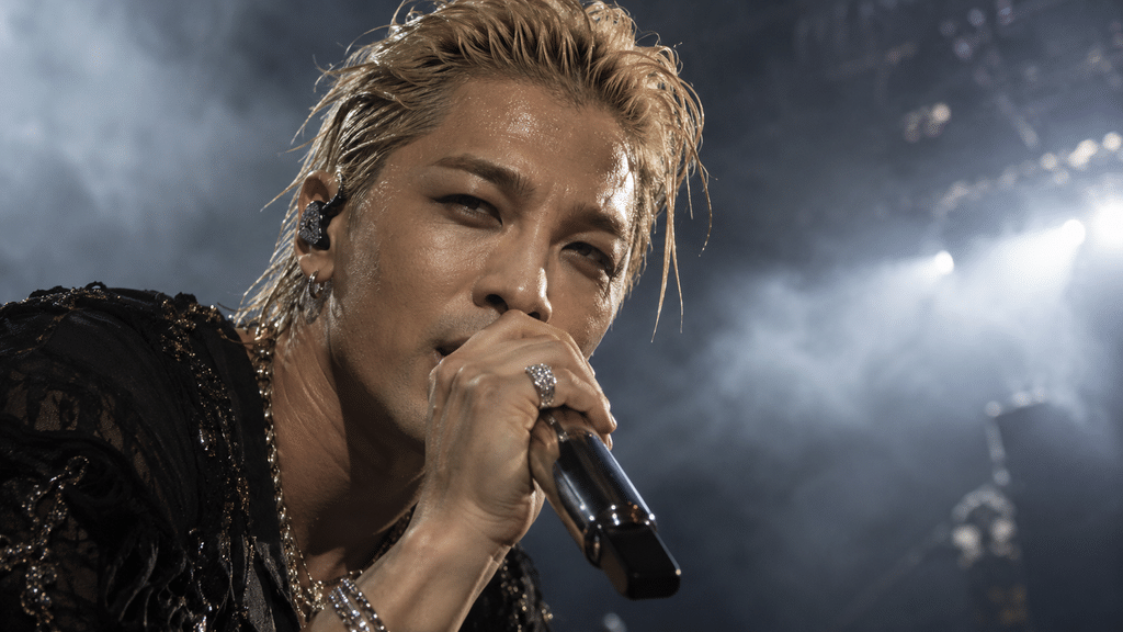 Taeyang BIGBANG Sempat Cemas Asap Halangi Wajah Fans di Singapura 2 Tampilan jarak dekat (close-up) Taeyang yang sedang memicingkan mata melihat ke arah lautan penonton di tengah tata cahaya panggung yang berkabut.